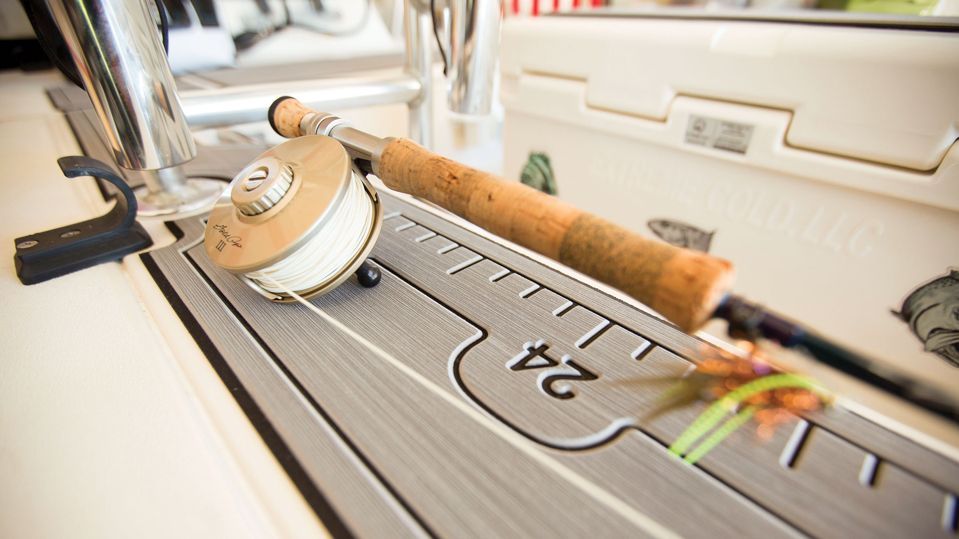 rod and reel next to a boat decking fish length measuring guide